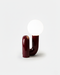 ARCA designer table lamp with sculptural U-shaped glossy burgundy ceramic base and white opal glass globe | DecoHarmonie