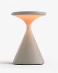KONI cordless table lamp, sculptural hourglass cone in matte stone-grey resin with warm glow | DecoHarmonie