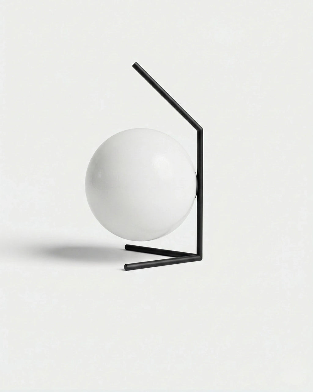 ENNA designer table lamp with white opal glass sphere globe on angled matte black metal frame | DecoHarmonie