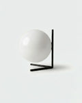 KAEN designer table lamp with white glass sphere cradled in angular black metal frame | DecoHarmonie