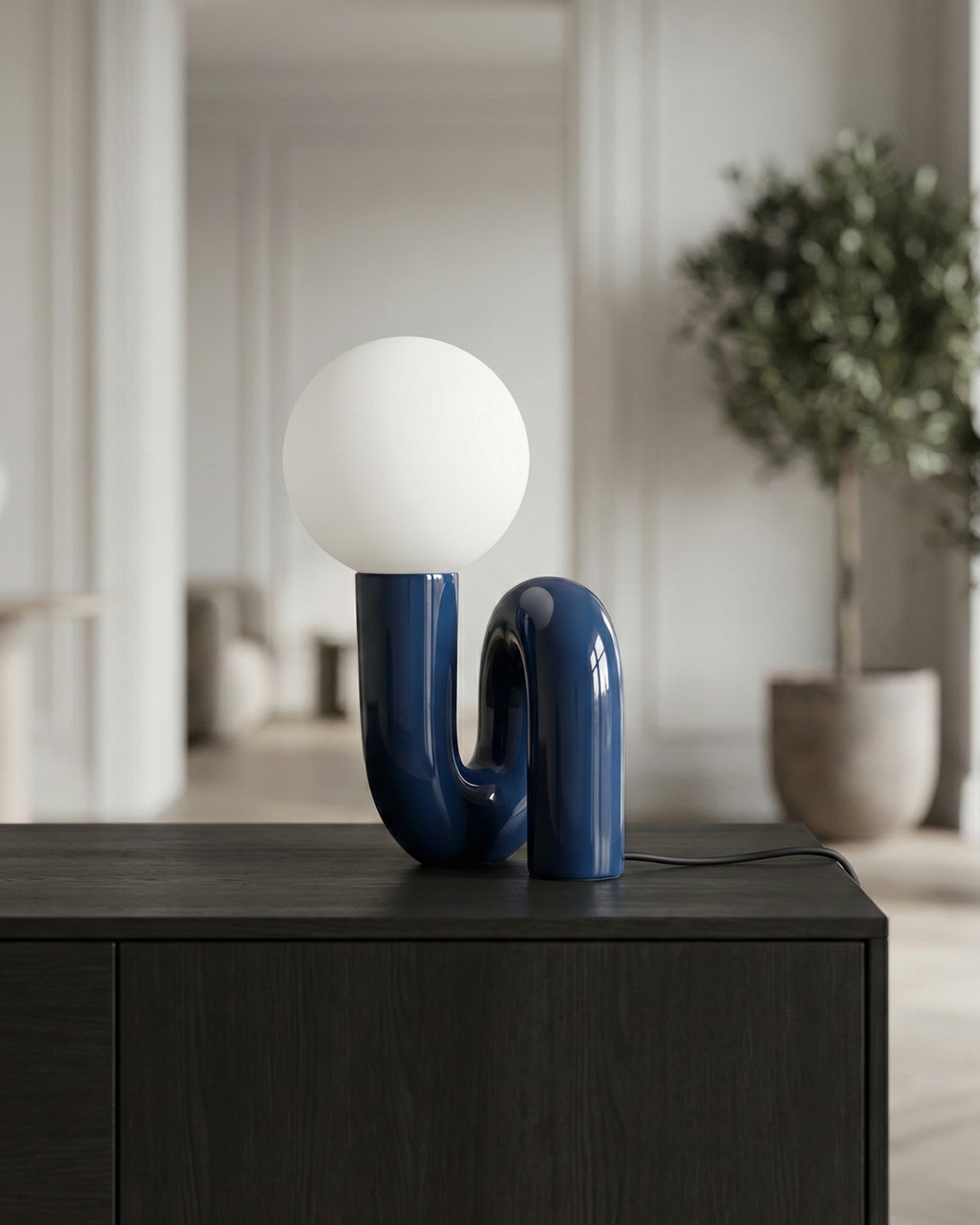 ARCA designer table lamp shown on a bedside table in a modern bedroom — DecoHarmonie