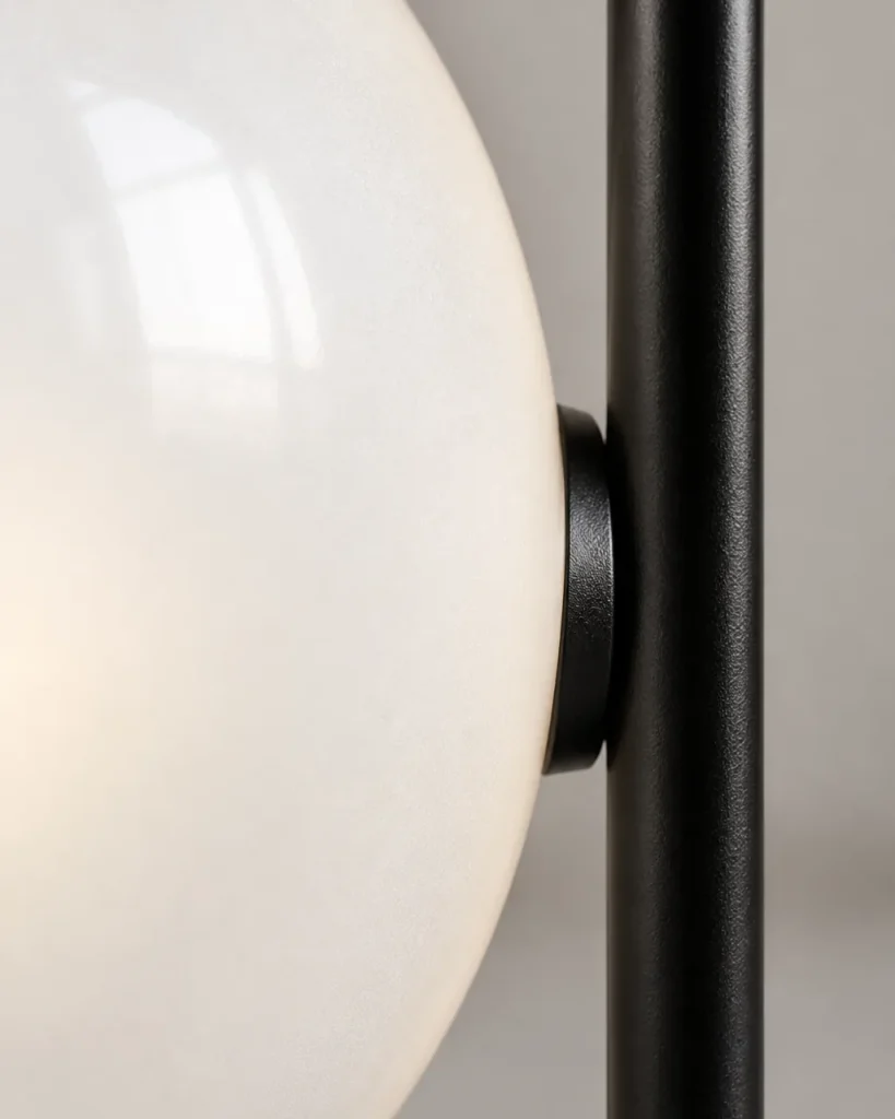 Tischlampe KAEN, Grosse Opalglaskugel mit schwarzem Winkelgestell – Detailansicht der Verbindung von Opalglaskugel und schwarzem Metallsteher