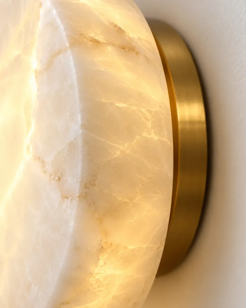 Wandlampe JILVA, Runde Alabaster-Wandleuchte in vier Grössen – Detailansicht der Alabasteradern und der Wandplatte in Messing