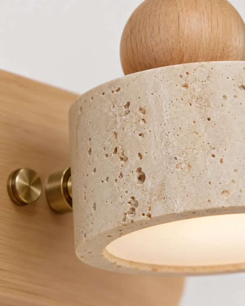 Applique MIKA, luce per specchio in travertino e legno massello – dettaglio di pori, snodo in legno e raccordo in ottone