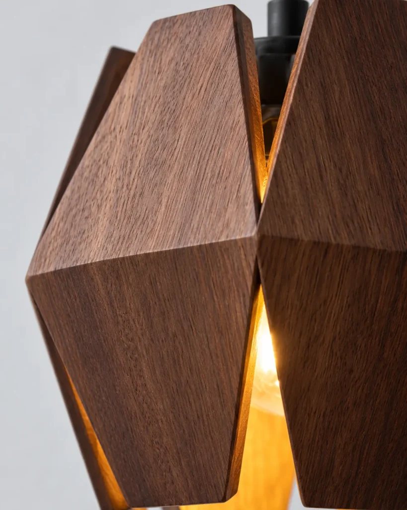 Wandlampe ALTO, facettierter Walnussschirm am Goldarm – Detailansicht der facettierten Holzsegmente